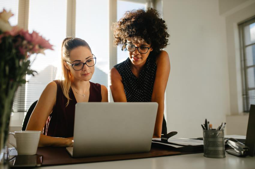 Two businesswoman loking at a laptop screen