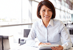 Asian business woman smiling at camera holding a planning book