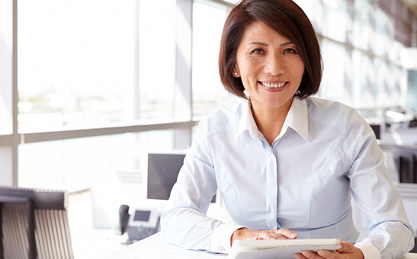 Asian business woman smiling at camera holding a planning book