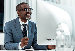 Smiling African American businessman please with working at his desktop computer.