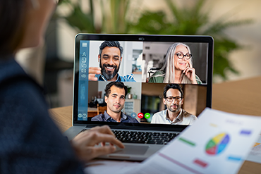 Businesswoman on a video confence with four works on her laptop screen.