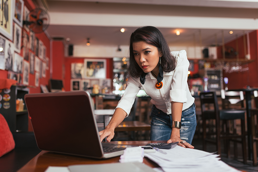 Concerned businesswoman reading intently while staring at computer screen