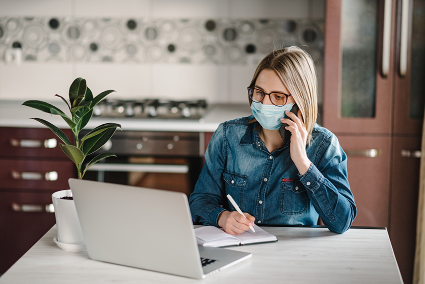 Concerned businesswoman looking at desktop computer screen and taking notes