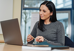 Women sitting at computer smiling at the screen