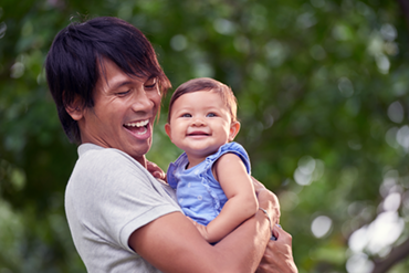 Smiling man holding smiling baby