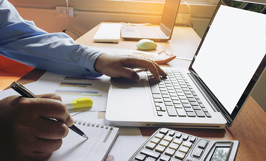 Image of a user's hands while entering information on a laptop computer in a workplace setting 